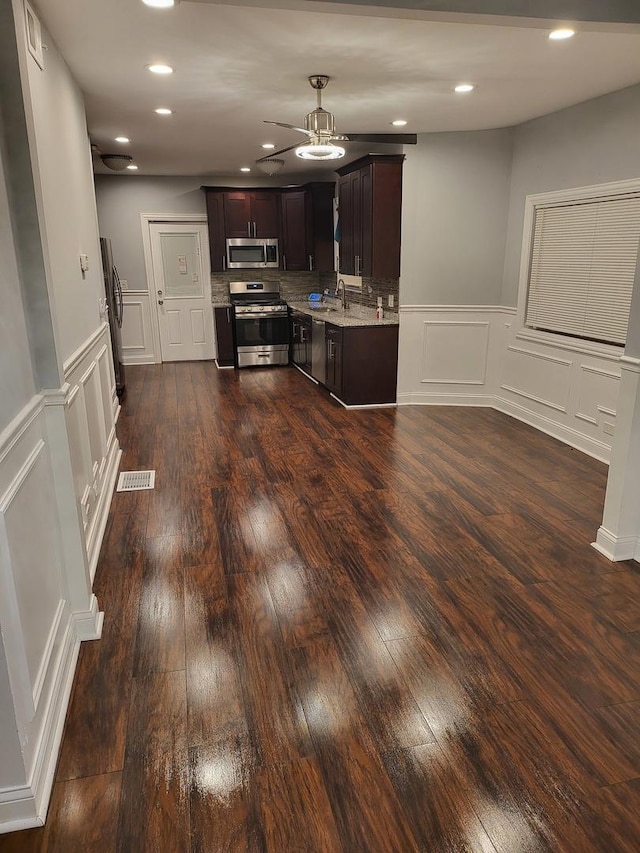 kitchen featuring decorative backsplash, dark hardwood / wood-style flooring, dark brown cabinetry, and appliances with stainless steel finishes