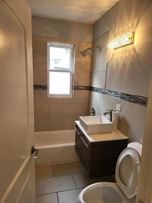 full bathroom featuring vanity, tiled shower / bath combo, tile walls, tile patterned flooring, and toilet