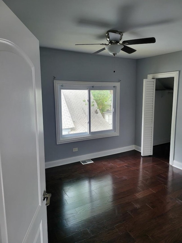 unfurnished bedroom with ceiling fan and dark hardwood / wood-style flooring