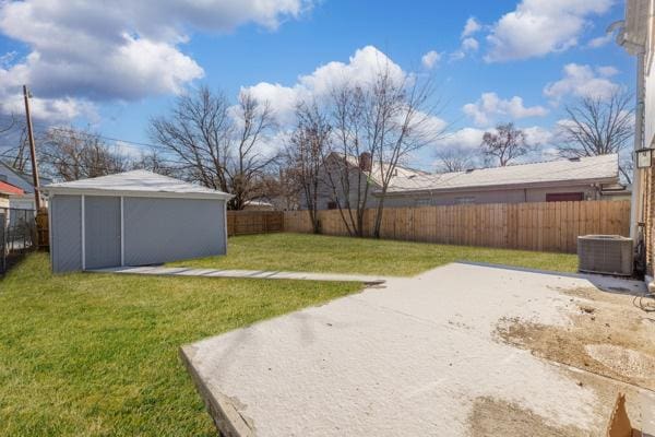 view of yard featuring central AC and a storage shed