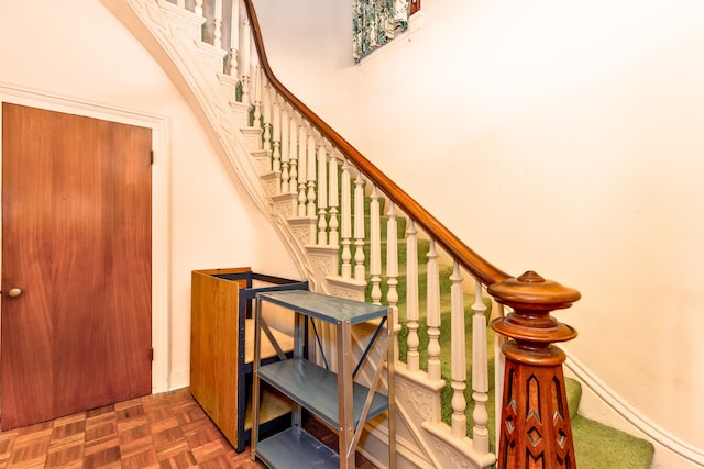 stairway featuring parquet flooring