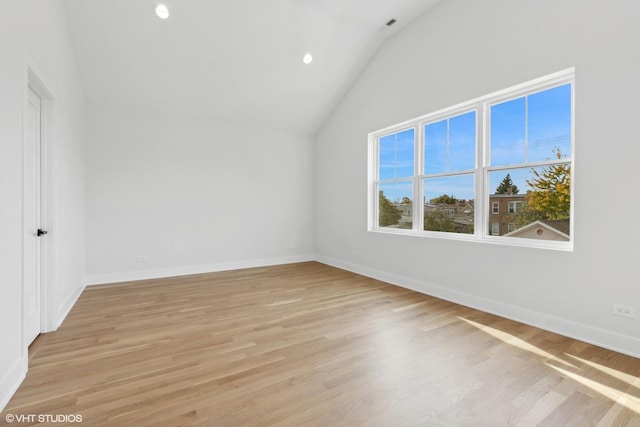 additional living space with light hardwood / wood-style floors and vaulted ceiling