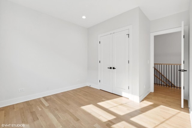 unfurnished bedroom featuring a closet and light wood-type flooring