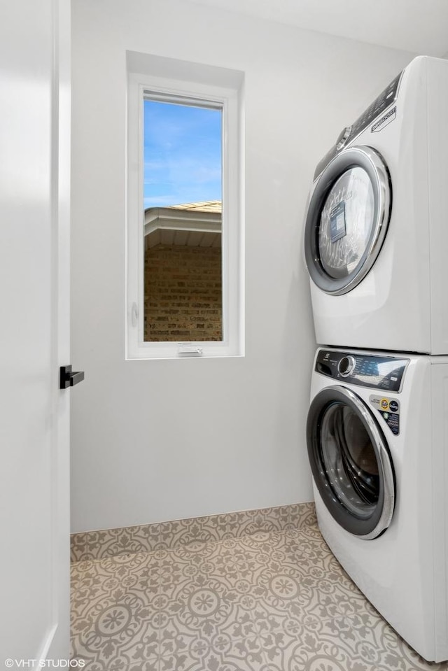 laundry area featuring stacked washer / dryer and light tile patterned flooring