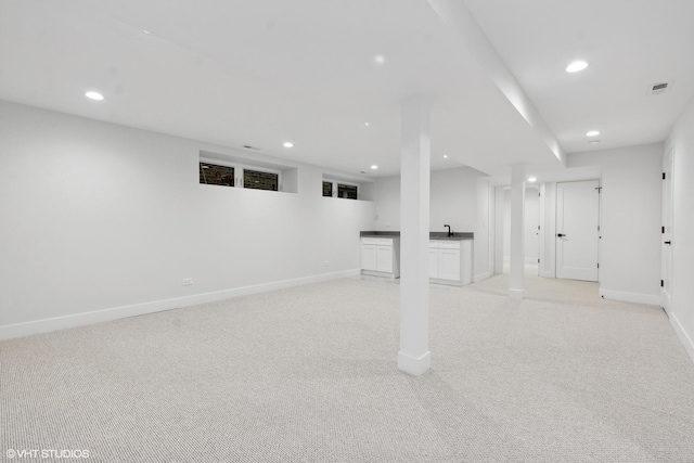 basement featuring light colored carpet