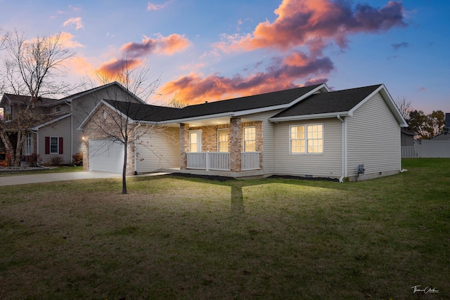 view of front of home with a yard, a porch, and a garage