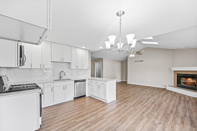 kitchen featuring white cabinetry, light hardwood / wood-style flooring, stainless steel appliances, and decorative light fixtures