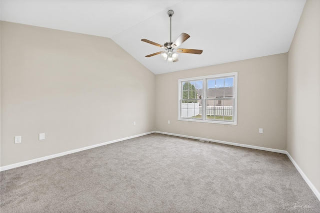 carpeted spare room with ceiling fan and vaulted ceiling