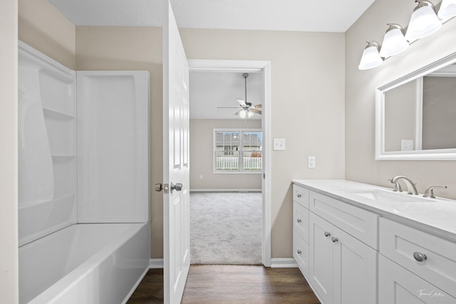 bathroom with shower / bathing tub combination, wood-type flooring, vanity, and ceiling fan