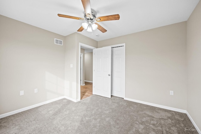 unfurnished bedroom featuring ceiling fan, a closet, and carpet