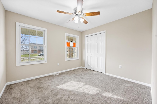 unfurnished bedroom featuring ceiling fan, carpet floors, and a closet