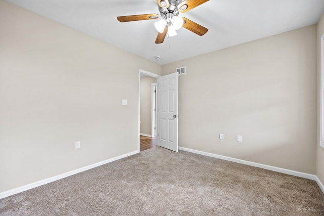 carpeted spare room with ceiling fan