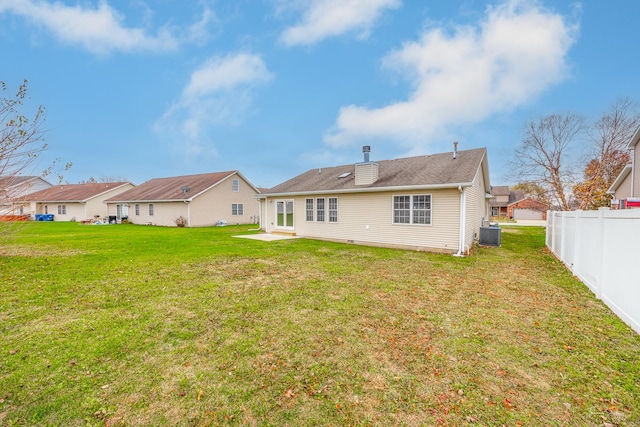 back of property featuring a yard and central air condition unit