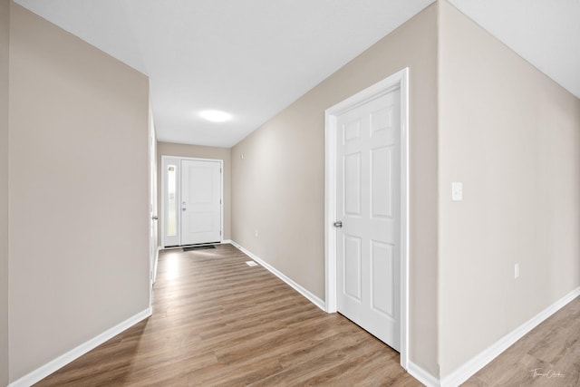 corridor with light hardwood / wood-style floors