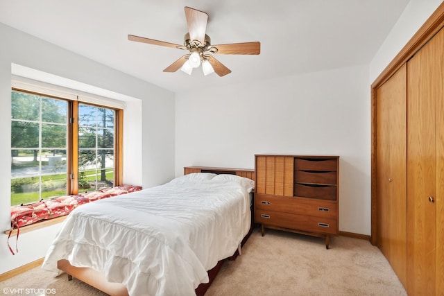 carpeted bedroom featuring ceiling fan and a closet