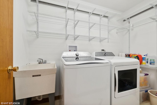 clothes washing area with washer and dryer and sink