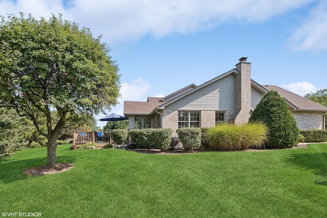 back of house with a deck and a lawn