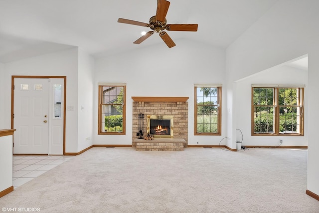 unfurnished living room featuring high vaulted ceiling, light colored carpet, a brick fireplace, and ceiling fan