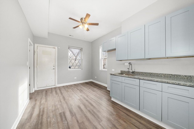 kitchen with gray cabinets, dark hardwood / wood-style floors, ceiling fan, and sink