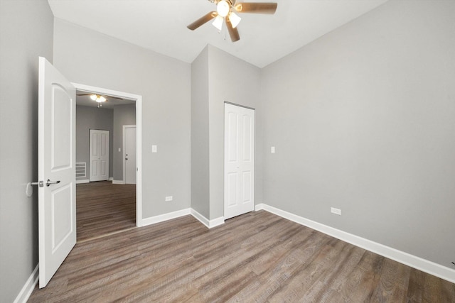 unfurnished bedroom featuring hardwood / wood-style floors, ceiling fan, and a closet