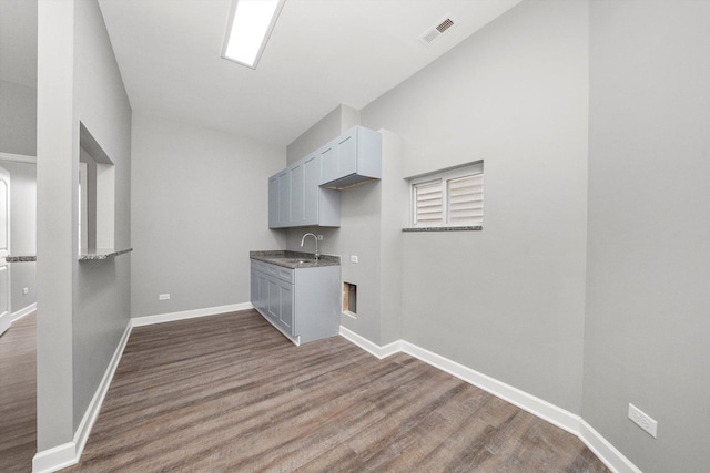 laundry area featuring sink and hardwood / wood-style flooring