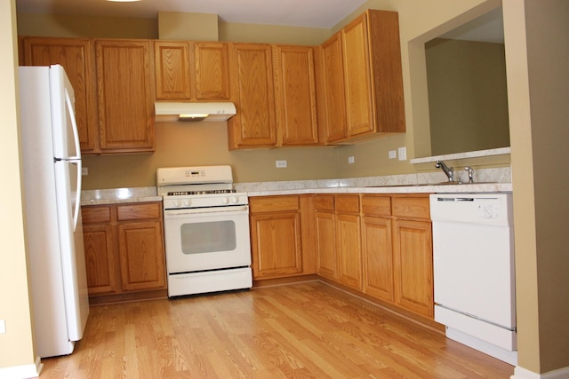 kitchen with sink, white appliances, and light wood-type flooring