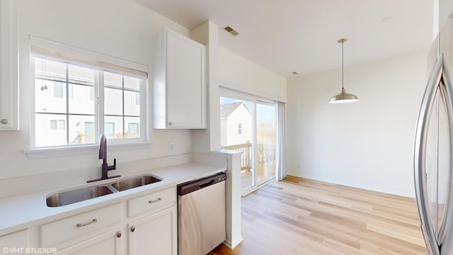 kitchen featuring white cabinetry, sink, stainless steel appliances, and light wood-type flooring