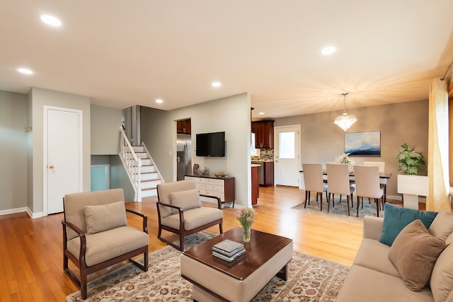 living room with light hardwood / wood-style flooring and a chandelier