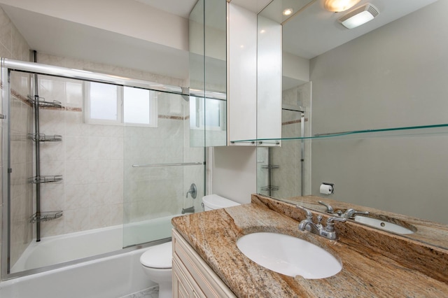 full bathroom with vanity, toilet, and bath / shower combo with glass door