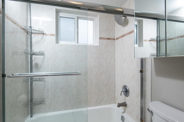 bathroom featuring bath / shower combo with glass door and toilet