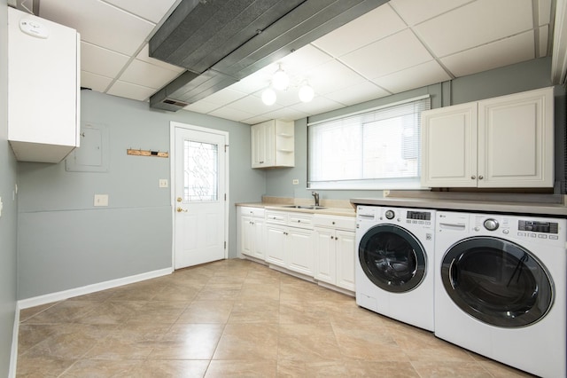 clothes washing area featuring sink, cabinets, washing machine and dryer, electric panel, and light tile patterned floors