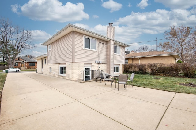 back of house with a patio area and a yard