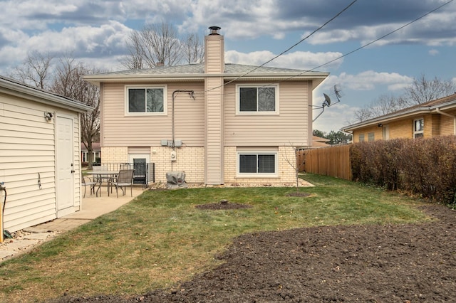 rear view of property featuring a lawn and a patio