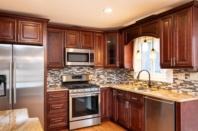 kitchen with light hardwood / wood-style flooring, sink, appliances with stainless steel finishes, and tasteful backsplash