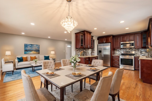 dining room featuring light wood-type flooring and an inviting chandelier