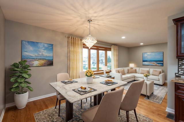 dining room with a chandelier and light wood-type flooring