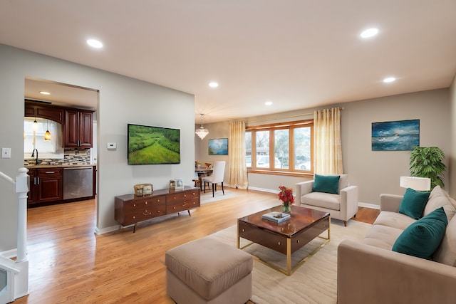 living room with light hardwood / wood-style floors and sink