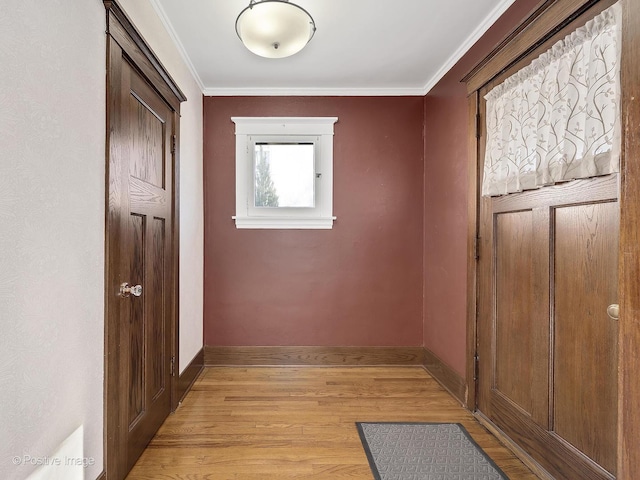 hallway featuring ornamental molding and light wood-type flooring