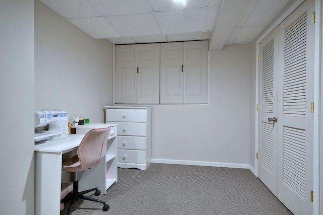 carpeted office featuring a paneled ceiling