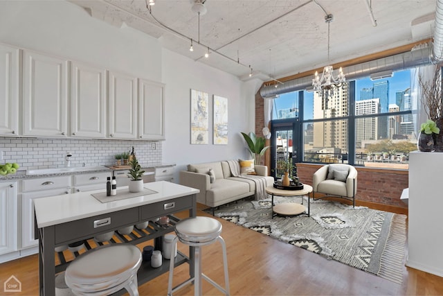 interior space featuring track lighting, light hardwood / wood-style flooring, and a notable chandelier