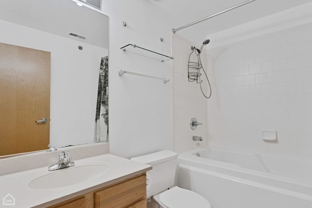 full bathroom with vanity, tiled shower / bath combo, and toilet