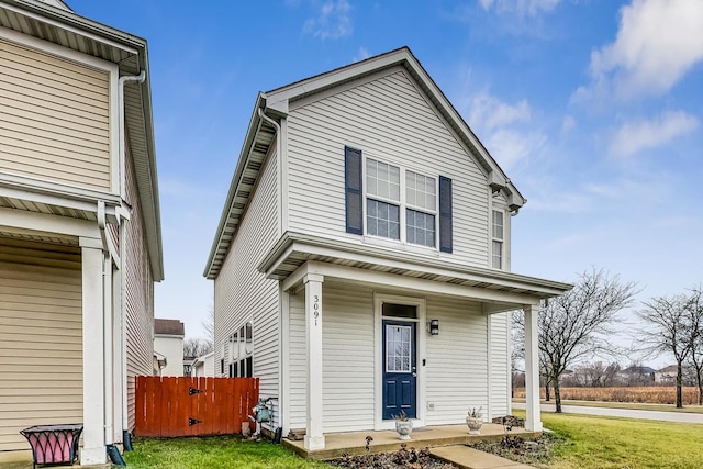 view of front property featuring covered porch and a front lawn