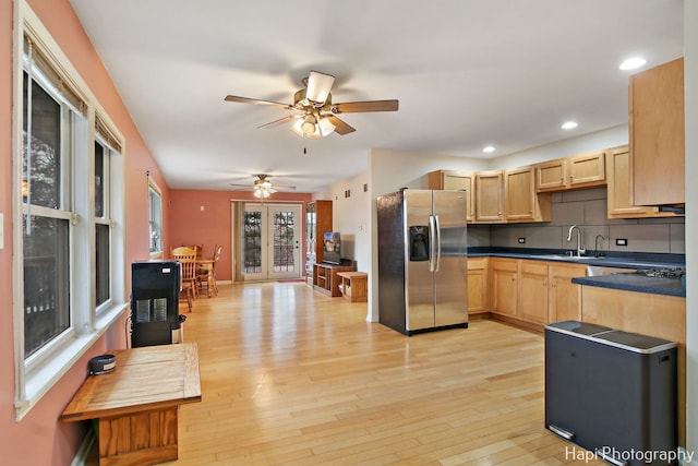 kitchen featuring light brown cabinets, sink, stainless steel fridge, light wood-type flooring, and tasteful backsplash