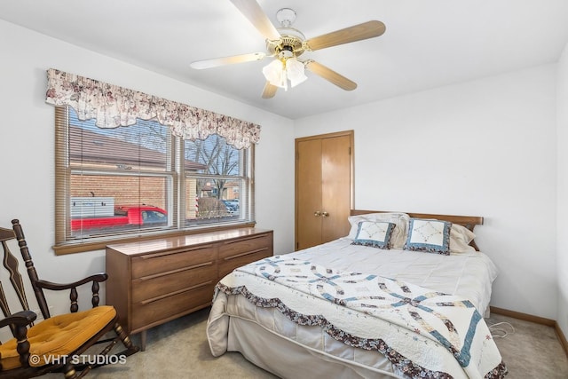 carpeted bedroom with ceiling fan and a closet