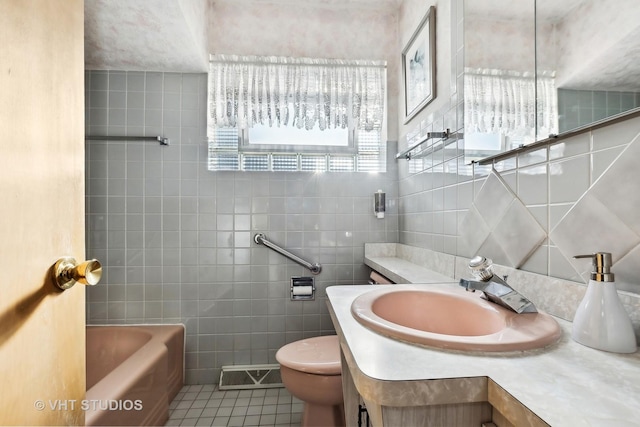 bathroom featuring tile patterned flooring, vanity, tile walls, and a tub