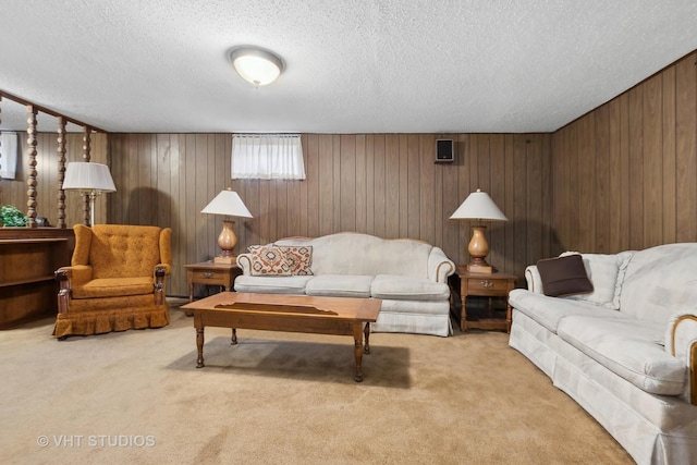 carpeted living room with a textured ceiling and wood walls