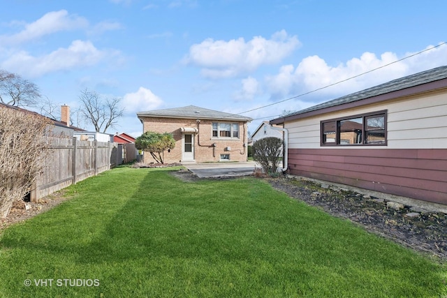 back of property with a yard and a patio