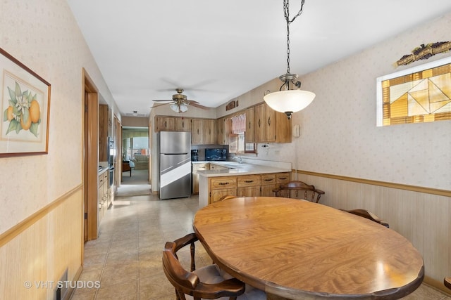 dining space with ceiling fan, sink, and light tile patterned floors