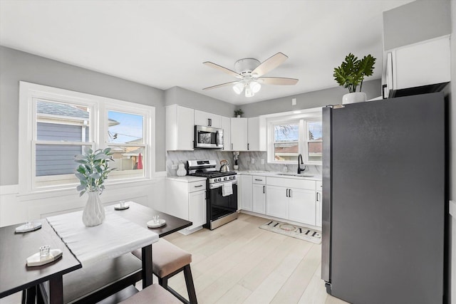 kitchen with white cabinetry, sink, a healthy amount of sunlight, and appliances with stainless steel finishes