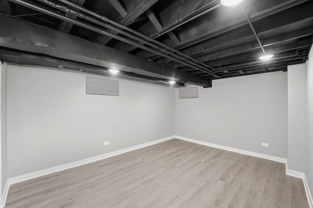 basement with hardwood / wood-style flooring